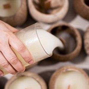 Pouring wax into coconut candles