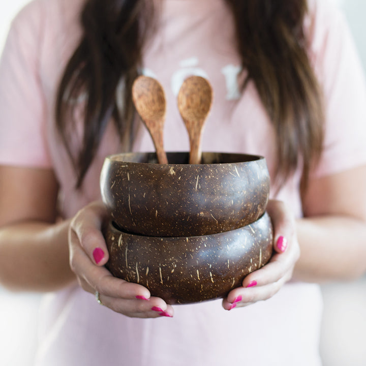 Holding coconut bowls and coconut spoons